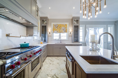 Photo of a large modern l-shaped kitchen pantry in Toronto with a submerged sink, shaker cabinets, grey cabinets, engineered stone countertops, white splashback, stone slab splashback, stainless steel appliances, marble flooring, an island and white floors.