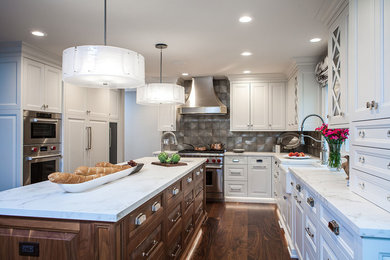 Inspiration for a large transitional u-shaped medium tone wood floor and brown floor eat-in kitchen remodel in Chicago with a farmhouse sink, recessed-panel cabinets, white cabinets, metallic backsplash, porcelain backsplash, stainless steel appliances, an island, gray countertops and quartz countertops