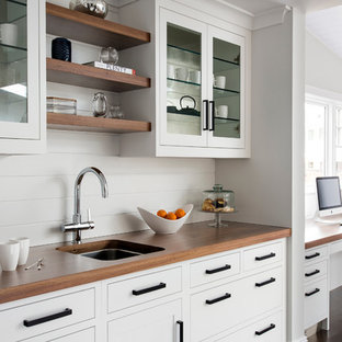 Large transitional l-shaped eat-in kitchen in New York with a single-bowl sink, shaker cabinets, white cabinets, limestone benchtops, grey splashback, stone slab splashback, stainless steel appliances, medium hardwood floors and with island.
