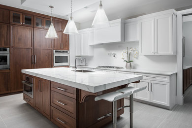 Example of a large transitional u-shaped porcelain tile and gray floor enclosed kitchen design in New York with beaded inset cabinets, white cabinets, an island, an undermount sink, marble countertops, white backsplash and stainless steel appliances