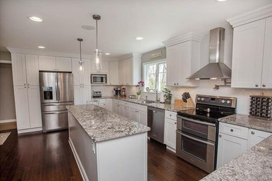 Large transitional u-shaped dark wood floor and brown floor eat-in kitchen photo in Bridgeport with an undermount sink, shaker cabinets, white cabinets, granite countertops, white backsplash, subway tile backsplash, stainless steel appliances, an island and gray countertops