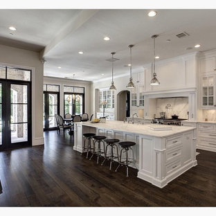 Large traditional open concept kitchen pictures - Open concept kitchen - large traditional l-shaped dark wood floor and brown floor open concept kitchen idea in Columbus with a farmhouse sink, recessed-panel cabinets, white cabinets, marble countertops, gray backsplash, marble backsplash, stainless steel appliances, an island and gray countertops