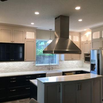 White cabinets with dark blue accents, recirculating hood, two-level island