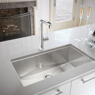This is an example of a large modern l-shaped eat-in kitchen in Houston with a single-bowl sink, flat-panel cabinets, quartz benchtops, stainless steel appliances, porcelain floors, multiple islands, brown cabinets and grey floor.
