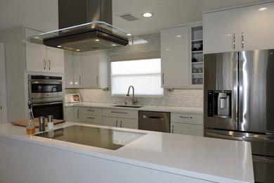 Example of a mid-sized trendy single-wall vinyl floor eat-in kitchen design in Tampa with an undermount sink, flat-panel cabinets, white cabinets, granite countertops, white backsplash, stone tile backsplash, stainless steel appliances and an island