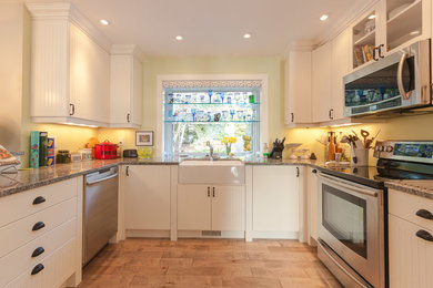 Inspiration for a timeless u-shaped kitchen remodel in Vancouver with a farmhouse sink, flat-panel cabinets, beige cabinets and stainless steel appliances