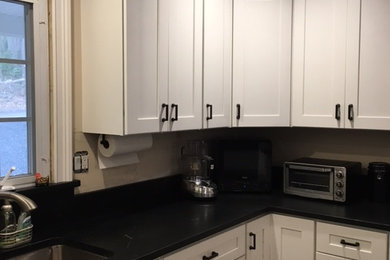 Example of a mid-sized minimalist u-shaped open concept kitchen design in New York with an undermount sink, shaker cabinets, white cabinets, stainless steel appliances and no island