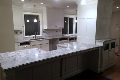 Large minimalist galley eat-in kitchen photo in Charleston with white cabinets, granite countertops and an island