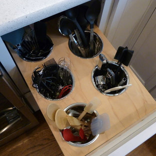 Design ideas for a mid-sized country l-shaped eat-in kitchen in Chicago with a farmhouse sink, recessed-panel cabinets, white cabinets, stainless steel appliances, medium hardwood floors and with island.