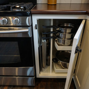 Inspiration for a small country u-shaped kitchen pantry in Columbus with a drop-in sink, shaker cabinets, white cabinets, white splashback, subway tile splashback, stainless steel appliances, dark hardwood floors, with island, brown floor and zinc benchtops.