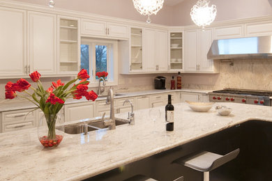 Bild på ett stort funkis kök, med en undermonterad diskho, luckor med upphöjd panel, vita skåp, bänkskiva i kvarts, beige stänkskydd, stänkskydd i sten, vita vitvaror, en köksö och klinkergolv i porslin