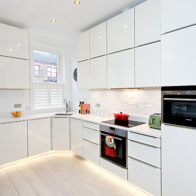 Kitchen - contemporary l-shaped light wood floor kitchen idea in London with flat-panel cabinets, white cabinets, white backsplash, no island and white countertops