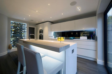 Moderne Küche mit Mineralwerkstoff-Arbeitsplatte, Küchenrückwand in Grau und Rückwand aus Spiegelfliesen in Hertfordshire