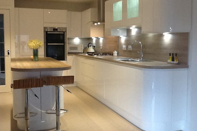 Foto de cocina minimalista con encimera de laminado, electrodomésticos de acero inoxidable y una isla