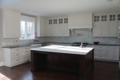 Huge elegant u-shaped dark wood floor eat-in kitchen photo in Indianapolis with a farmhouse sink, shaker cabinets, white cabinets, gray backsplash and two islands