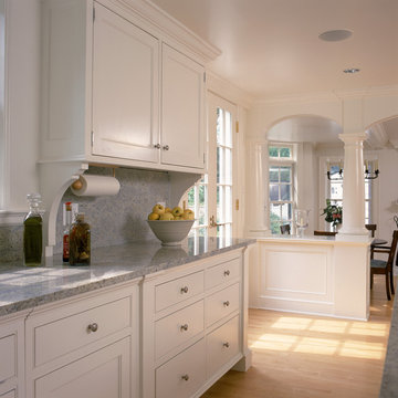 White kitchen and breakfast room with fireplace and arches