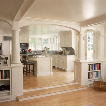 White kitchen and breakfast room with fireplace and arches