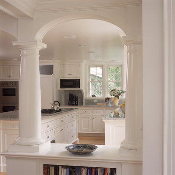 White kitchen and breakfast room with fireplace and arches
