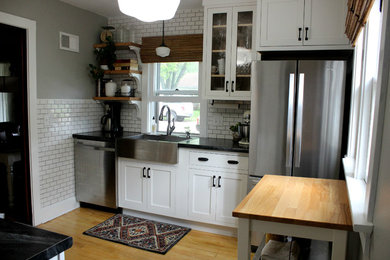 Inspiration for a small cottage galley light wood floor enclosed kitchen remodel in Other with a farmhouse sink, shaker cabinets, white cabinets, soapstone countertops, white backsplash, subway tile backsplash, stainless steel appliances and no island