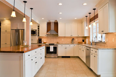 Example of a large classic u-shaped ceramic tile and multicolored floor eat-in kitchen design with a double-bowl sink, recessed-panel cabinets, white cabinets, solid surface countertops, white backsplash, ceramic backsplash, stainless steel appliances, an island and multicolored countertops