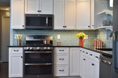 Example of a mid-sized transitional l-shaped medium tone wood floor eat-in kitchen design in Cleveland with an undermount sink, recessed-panel cabinets, white cabinets, blue backsplash and subway tile backsplash