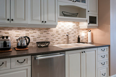Example of a small classic galley ceramic tile eat-in kitchen design in Montreal with a drop-in sink, raised-panel cabinets, white cabinets, laminate countertops, multicolored backsplash, mosaic tile backsplash, stainless steel appliances and no island