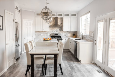 Mid-sized elegant u-shaped vinyl floor and gray floor eat-in kitchen photo in Baltimore with an undermount sink, white cabinets, quartz countertops, ceramic backsplash, stainless steel appliances, an island, white countertops and raised-panel cabinets