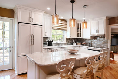 Design ideas for a classic enclosed kitchen in Baltimore with recessed-panel cabinets, white cabinets, beige splashback, integrated appliances, light hardwood flooring and an island.