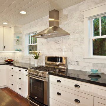 White Kitchen with wood island, carrara backsplash, black granite