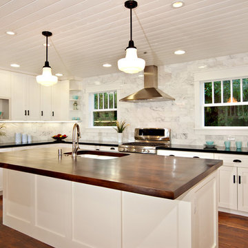 White Kitchen with wood island, carrara backsplash, black granite