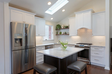 Eat-in kitchen - mid-sized transitional l-shaped medium tone wood floor eat-in kitchen idea in New York with an undermount sink, recessed-panel cabinets, white cabinets, marble countertops, white backsplash, ceramic backsplash, stainless steel appliances and an island