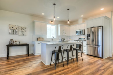 Eat-in kitchen - mid-sized contemporary l-shaped brown floor eat-in kitchen idea in Portland with shaker cabinets, white cabinets, granite countertops, an island and white countertops