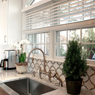 Mid-sized contemporary eat-in kitchen appliance - Eat-in kitchen - mid-sized contemporary l-shaped light wood floor eat-in kitchen idea in Philadelphia with a farmhouse sink, shaker cabinets, white cabinets, quartzite countertops, white backsplash, stone tile backsplash, stainless steel appliances and an island