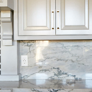 Large transitional open concept kitchen appliance - Example of a large transitional medium tone wood floor and brown floor open concept kitchen design in Other with a farmhouse sink, raised-panel cabinets, white cabinets, quartzite countertops, gray backsplash, mosaic tile backsplash, stainless steel appliances, an island and white countertops