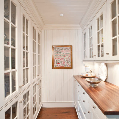 Elegant kitchen pantry photo in Indianapolis with wood countertops, glass-front cabinets and white cabinets