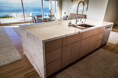 Eat-in kitchen - mid-sized contemporary single-wall limestone floor eat-in kitchen idea in Santa Barbara with an undermount sink, louvered cabinets, marble countertops, white backsplash, matchstick tile backsplash and an island