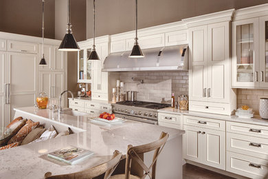 Large transitional l-shaped vinyl floor eat-in kitchen photo in Manchester with a farmhouse sink, beaded inset cabinets, white cabinets, quartzite countertops, white backsplash, subway tile backsplash, stainless steel appliances, an island and white countertops