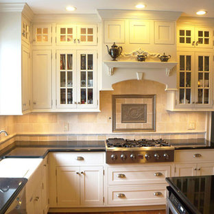 Mid-sized traditional eat-in kitchen designs - Mid-sized elegant l-shaped dark wood floor eat-in kitchen photo in New York with a farmhouse sink, beaded inset cabinets, white cabinets, granite countertops, multicolored backsplash, mosaic tile backsplash, stainless steel appliances and an island