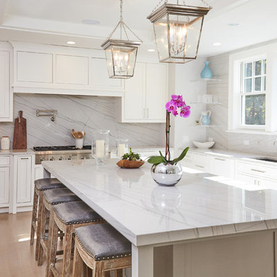 Kitchen - transitional l-shaped light wood floor kitchen idea in New York with an undermount sink, shaker cabinets, quartzite countertops, white backsplash, stone slab backsplash, stainless steel appliances, an island and white cabinets