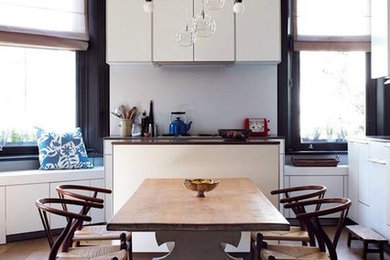 Idéer för ett mellanstort modernt vit kök, med släta luckor, vita skåp, ljust trägolv, en nedsänkt diskho, bänkskiva i kvarts, vitt stänkskydd, stänkskydd i keramik, rostfria vitvaror och brunt golv