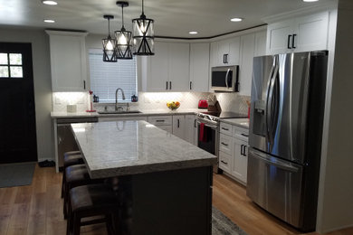 Inspiration for a large contemporary l-shaped eat-in kitchen remodel in Boise with shaker cabinets, white cabinets, quartz countertops, white backsplash, stainless steel appliances, an island and gray countertops