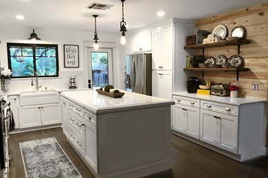 Modelo de cocina actual con fregadero sobremueble, armarios estilo shaker, puertas de armario blancas, electrodomésticos de acero inoxidable, una isla y encimeras blancas