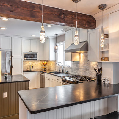 Eat-in kitchen - mid-sized craftsman u-shaped light wood floor eat-in kitchen idea in Burlington with an undermount sink, shaker cabinets, white cabinets, soapstone countertops, white backsplash, stone tile backsplash, stainless steel appliances and an island