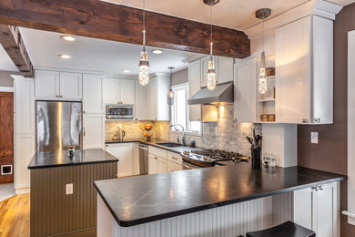 Eat-in kitchen - mid-sized craftsman u-shaped light wood floor eat-in kitchen idea in Burlington with an undermount sink, shaker cabinets, white cabinets, soapstone countertops, white backsplash, stone tile backsplash, stainless steel appliances and an island