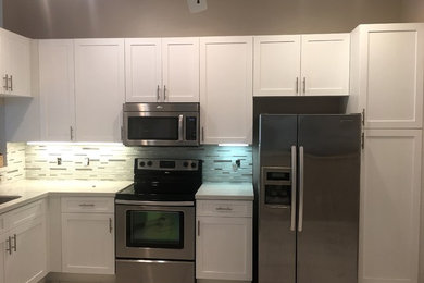 Mid-sized minimalist eat-in kitchen photo in Miami with shaker cabinets, white cabinets, quartz countertops, gray countertops, a double-bowl sink, gray backsplash and stainless steel appliances