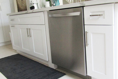 Modelo de cocina clásica renovada de tamaño medio con armarios estilo shaker, puertas de armario blancas, encimera de cuarcita, una isla y encimeras blancas
