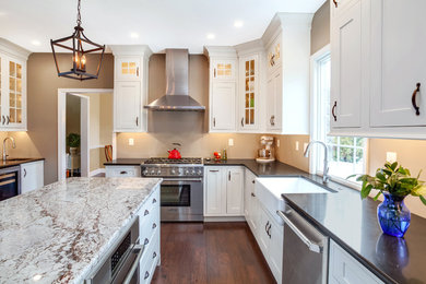 Large transitional l-shaped dark wood floor and brown floor enclosed kitchen photo in Philadelphia with a farmhouse sink, stainless steel appliances, an island, shaker cabinets, white cabinets and granite countertops