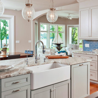 Idee per una cucina classica di medie dimensioni con lavello stile country, ante con riquadro incassato, ante verdi, top in quarzite, paraspruzzi blu, paraspruzzi con piastrelle di vetro, pavimento in legno massello medio e isola