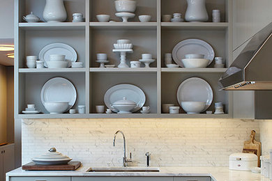 Foto på ett stort funkis kök, med en undermonterad diskho, släta luckor, marmorbänkskiva, stänkskydd i stenkakel, rostfria vitvaror, mellanmörkt trägolv, en köksö och grå skåp