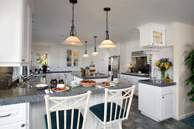 他の地域にある高級な中くらいなトラディショナルスタイルのおしゃれなキッチン (ダブルシンク、レイズドパネル扉のキャビネット、白いキャビネット、シルバーの調理設備、グレーの床) の写真